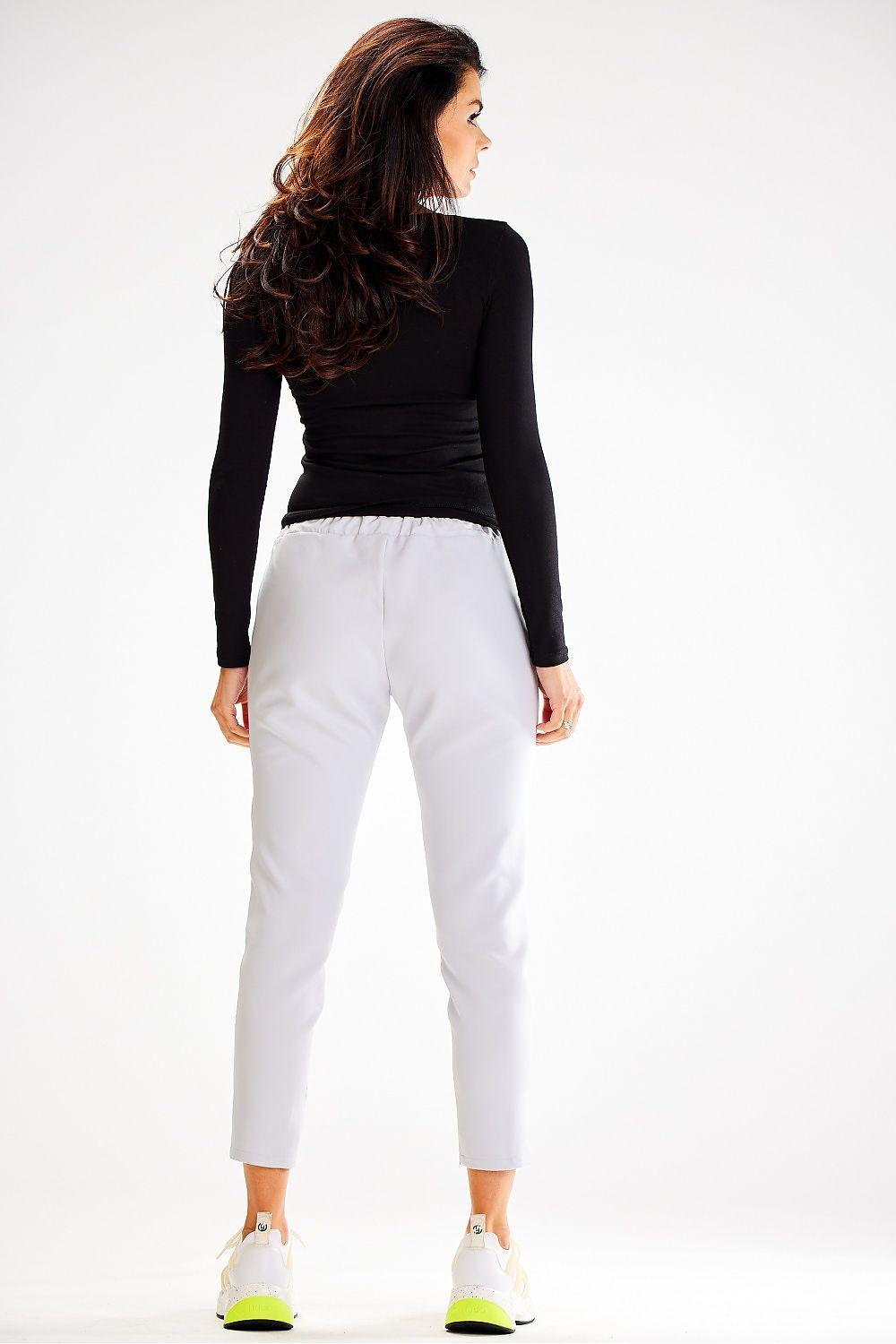 White tracksuit trousers with elastic waistband and drawstring, ankle-length straight taper.