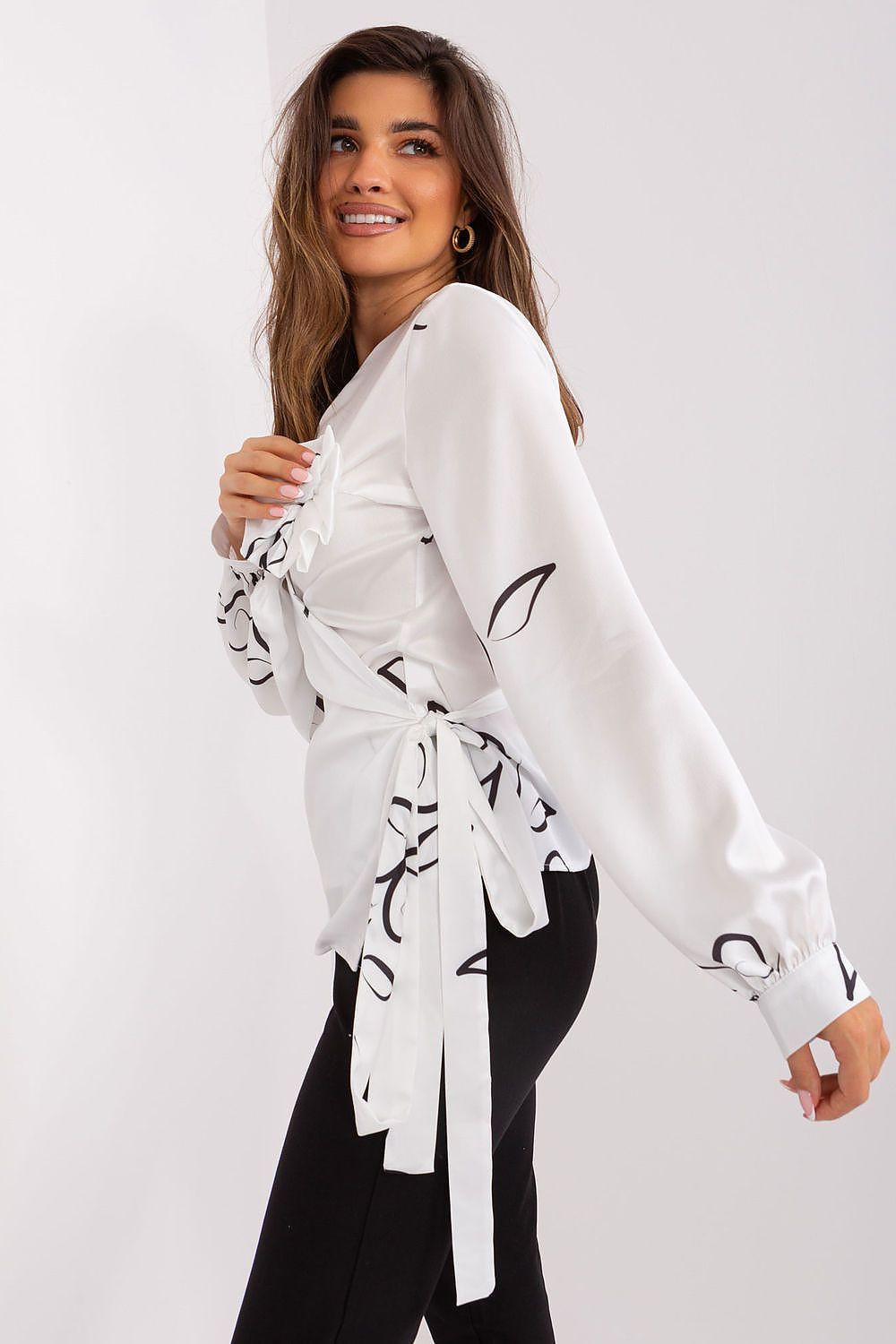 White Lakerta blouse with V-neck, black vine print, and bow tie sleeve detail