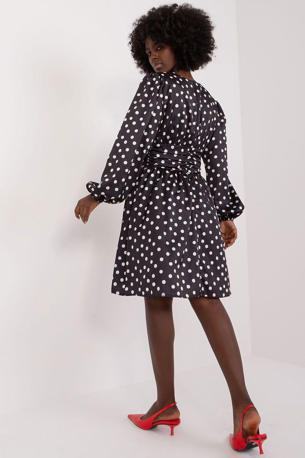 Black polka dot A-line cocktail dress with long sleeves and gathered skirt at waist