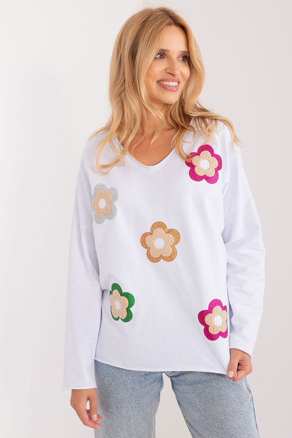 White cotton blouse with long sleeves and colorful floral appliques