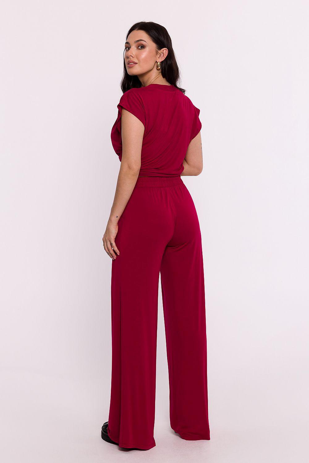 Red wide-leg women’s trousers with relaxed waist and long straight leg style.