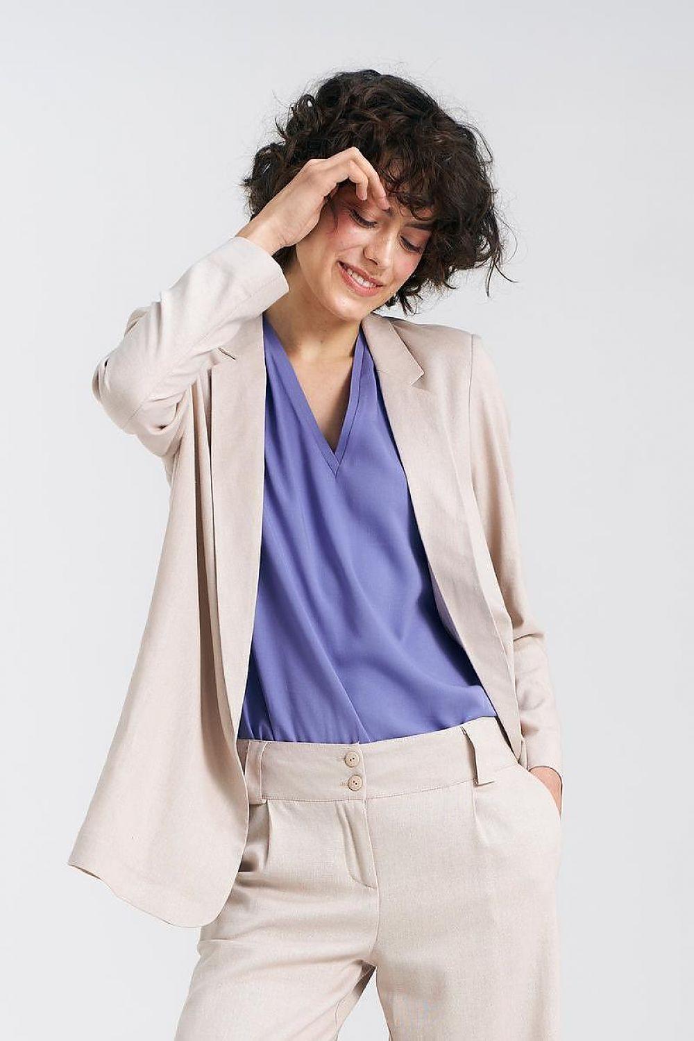 Women's beige blazer with notch lapels over blue top, long sleeves