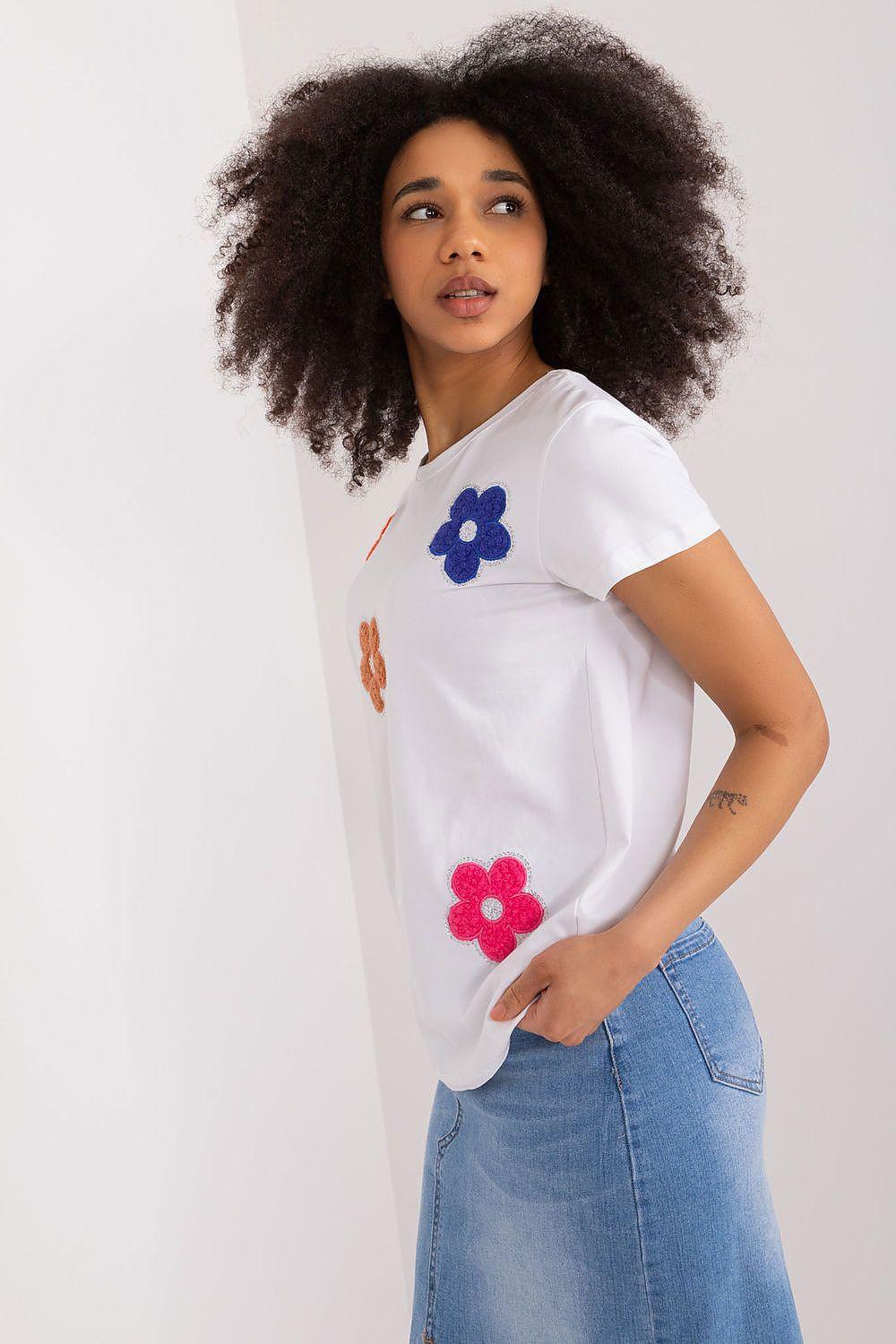 White short-sleeve blouse with blue and pink flower appliques, angled front view
