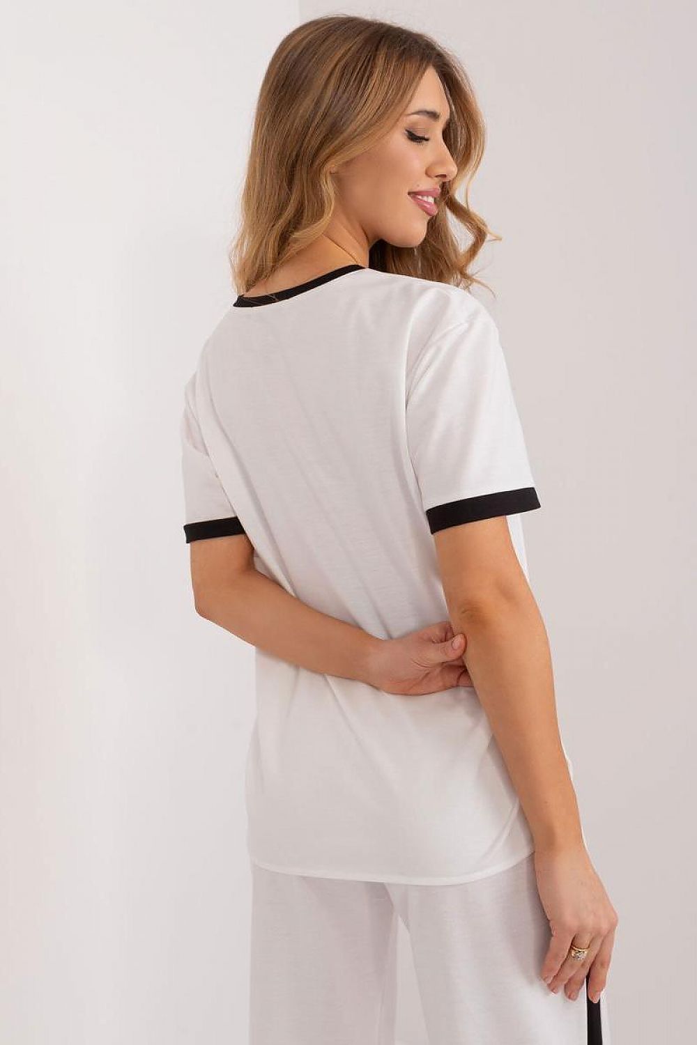 White blouse with black-trim sleeves and back yoke detail.