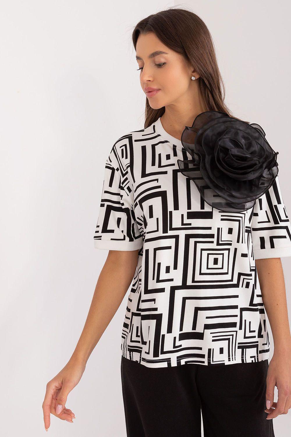 Geometric print blouse with black flower brooch, white base and black abstract blocks