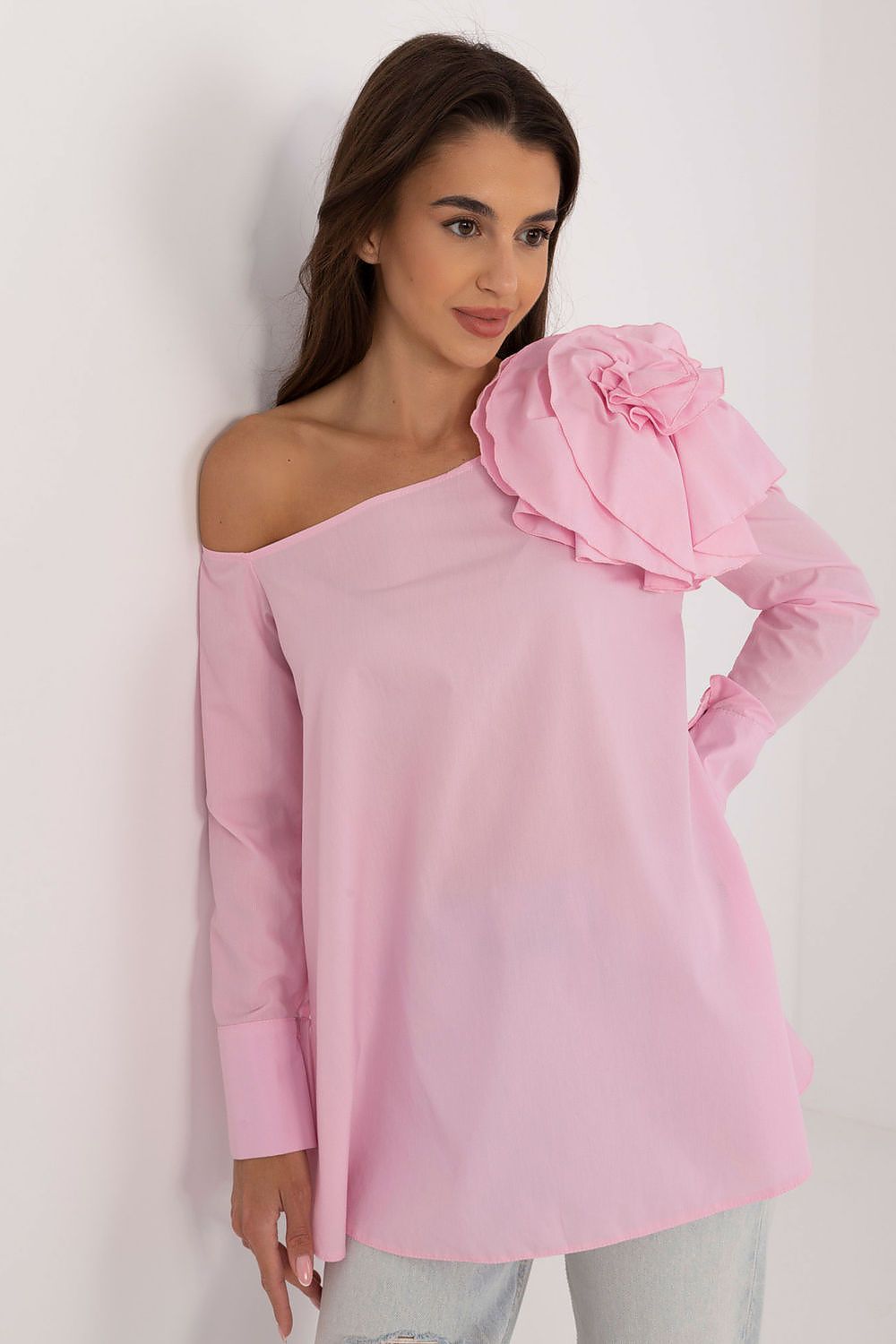 Pink asymmetrical neck blouse with large flower brooch