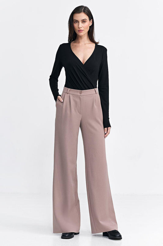 Beige wide-leg trousers with high-rise waist and button-front closure on model