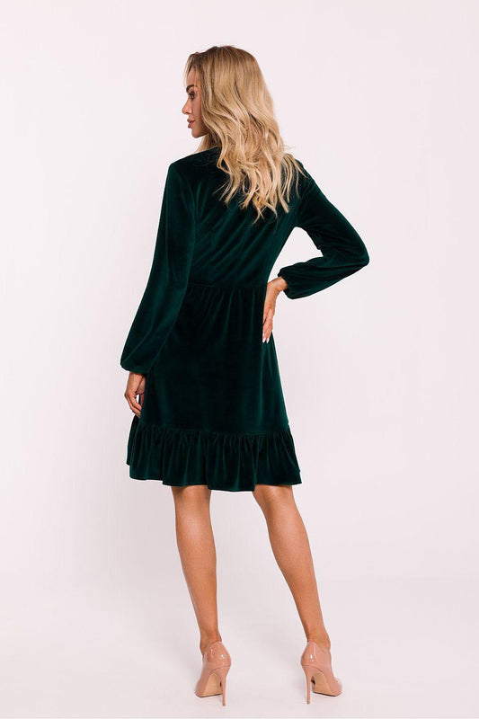 Deep green velour daydress, V-neck and long sleeves, side view with ruffle hem.
