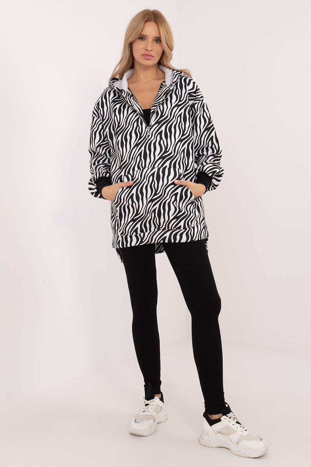 Zebra-print hooded jacket with black leggings, standing view