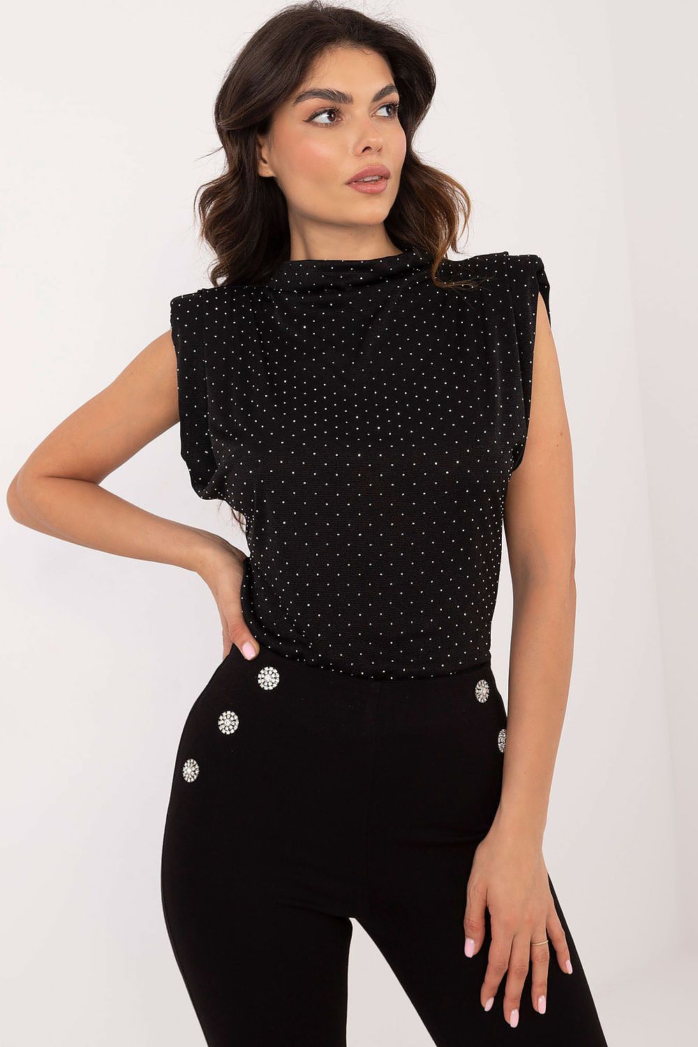 Black sleeveless blouse with high neckline, allover dots, and round white buttons