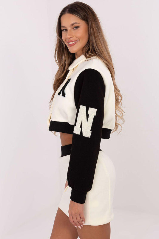 Women’s varsity skirt set with cream-and-black varsity jacket and matching mini skirt