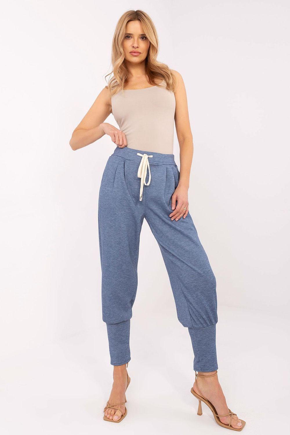 Blue tracksuit trousers with white drawstring, relaxed taper, and elastic ankle cuffs
