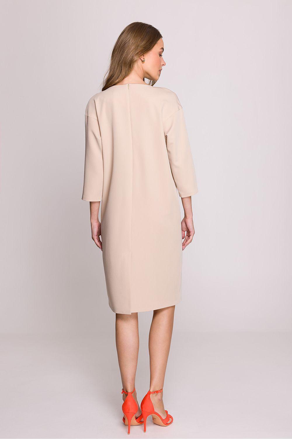 Beige daydress from the back with three-quarter sleeves and straight knee-length cut.