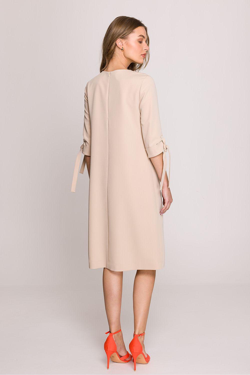 Beige knee-length daydress, back view, elbow sleeves with ribbon-tied cuffs