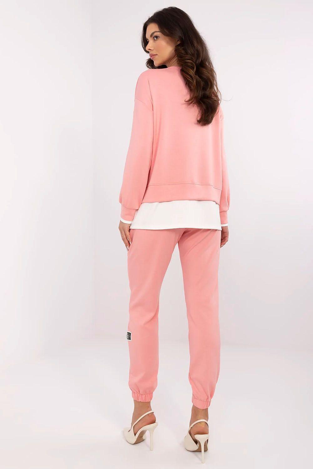 Pink crewneck sweatshirt and matching joggers with white hem and cuffed ankles