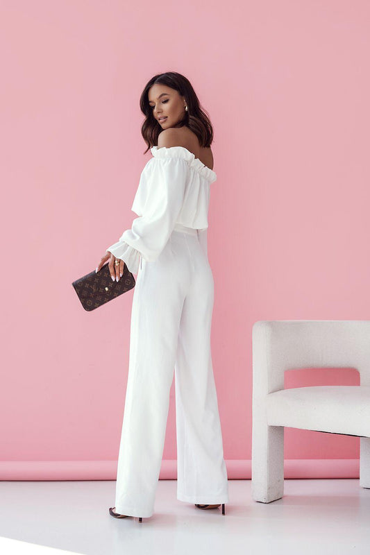White off-shoulder top and high-waist wide-leg trousers, side view