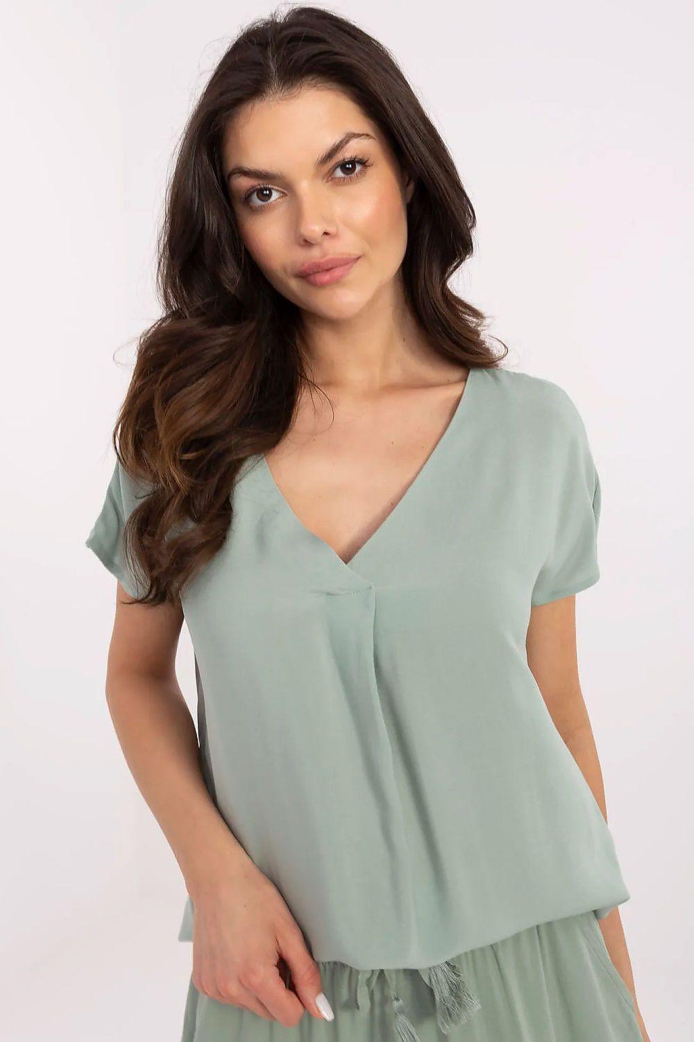 Green V-neck short-sleeve blouse with gathered trim at hem.