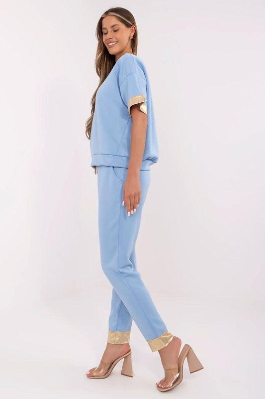 Light blue two-piece tracksuit set with draped short-sleeve top and slim ankle pants, gold hem