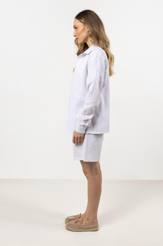 White cotton long sleeve shirt with stand collar, button front, side view.