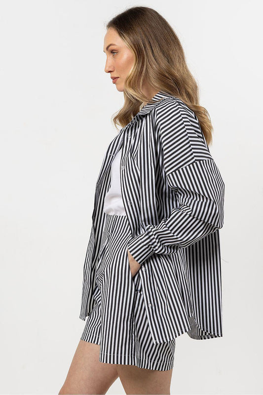 Black and white striped long-sleeve shirt with collar and loose drape, side view.