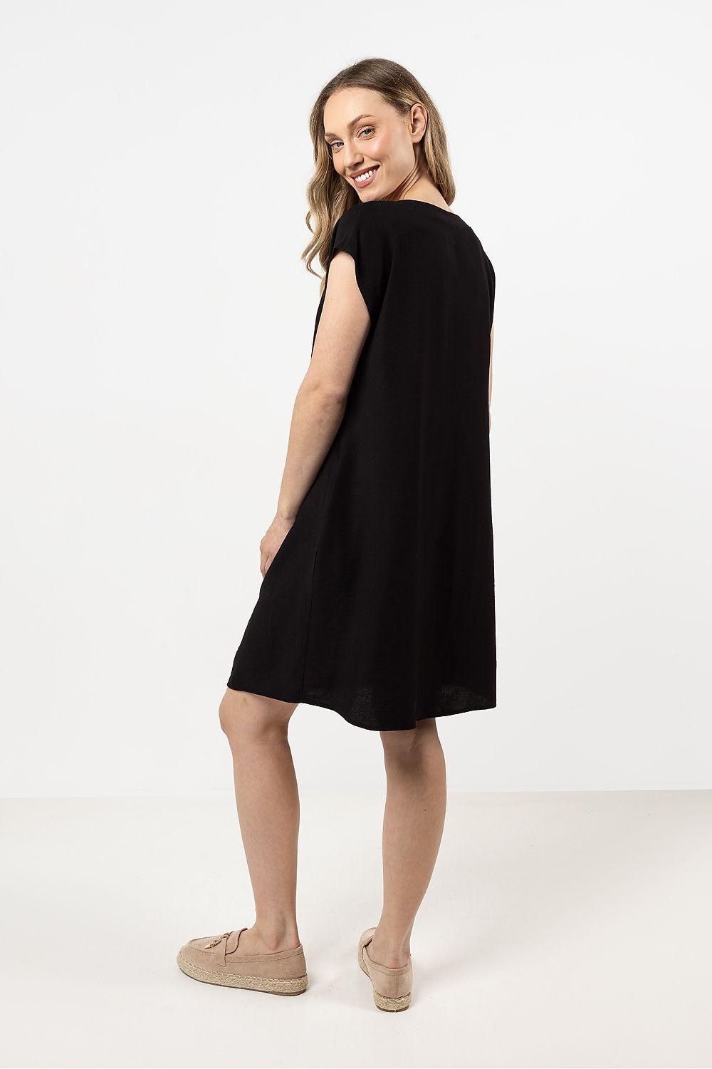 Black sleeveless daydress, angled side view; above-knee shift hem.
