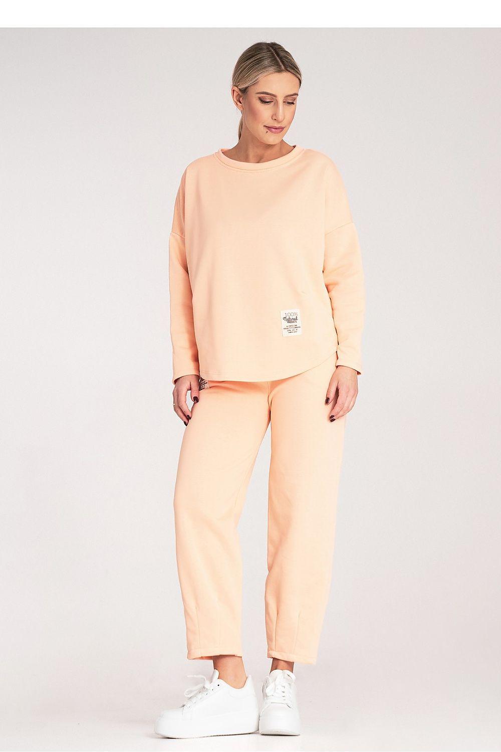 Two-piece loungewear set in light orange with crewneck sweatshirt and cuffed pants