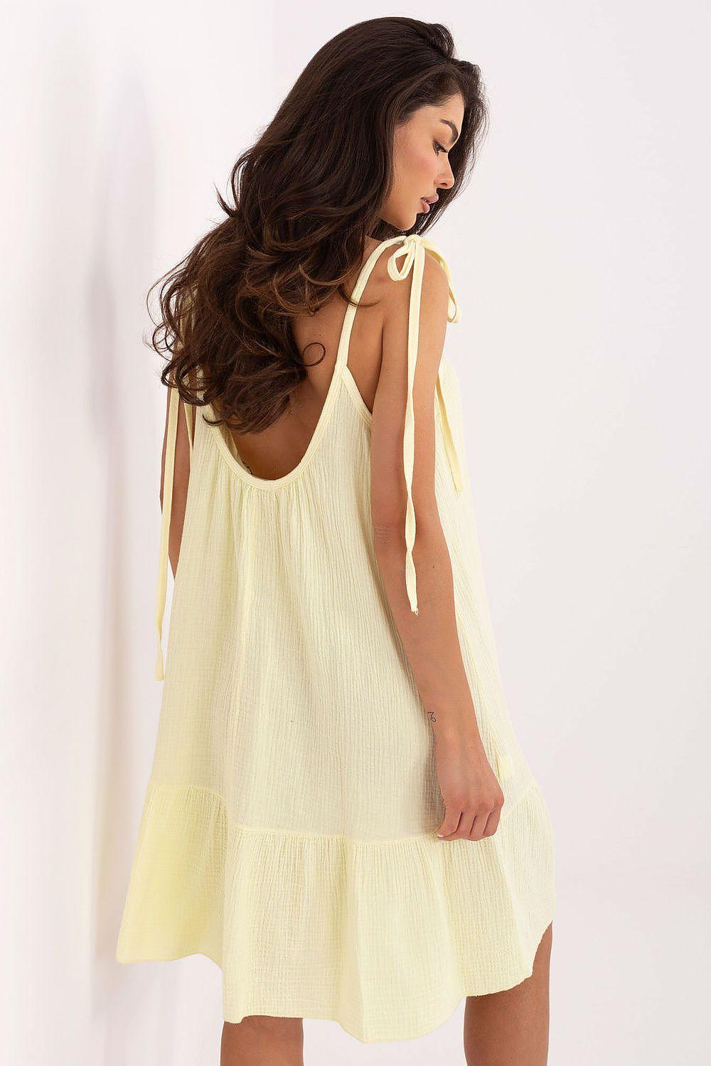 Yellow cotton muslin daydress with open-back tie straps and ruffle hem