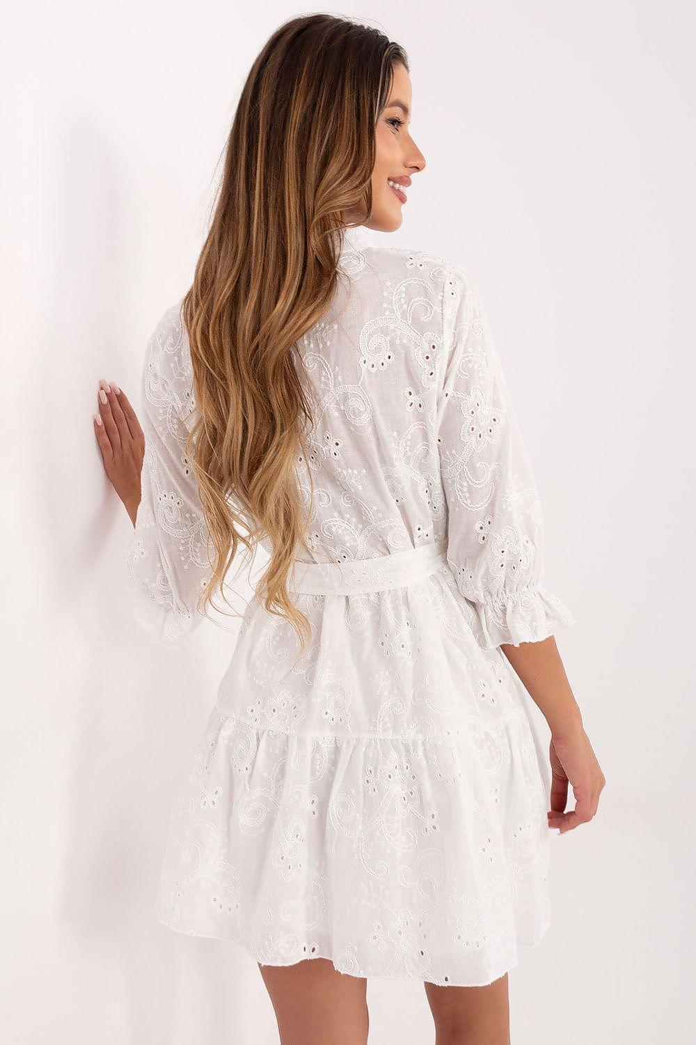 White eyelet daydress with long sleeves, tiered skirt, and tied waist belt