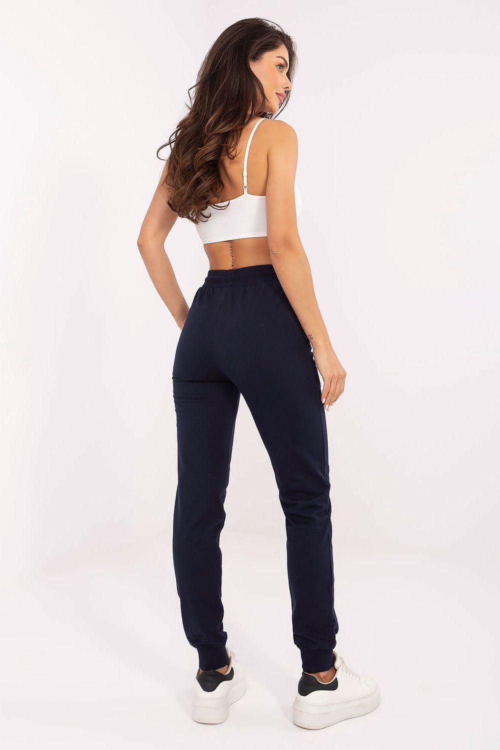 Navy track trousers in jogger style with drawstring waist and tapered legs, cuffed hem.