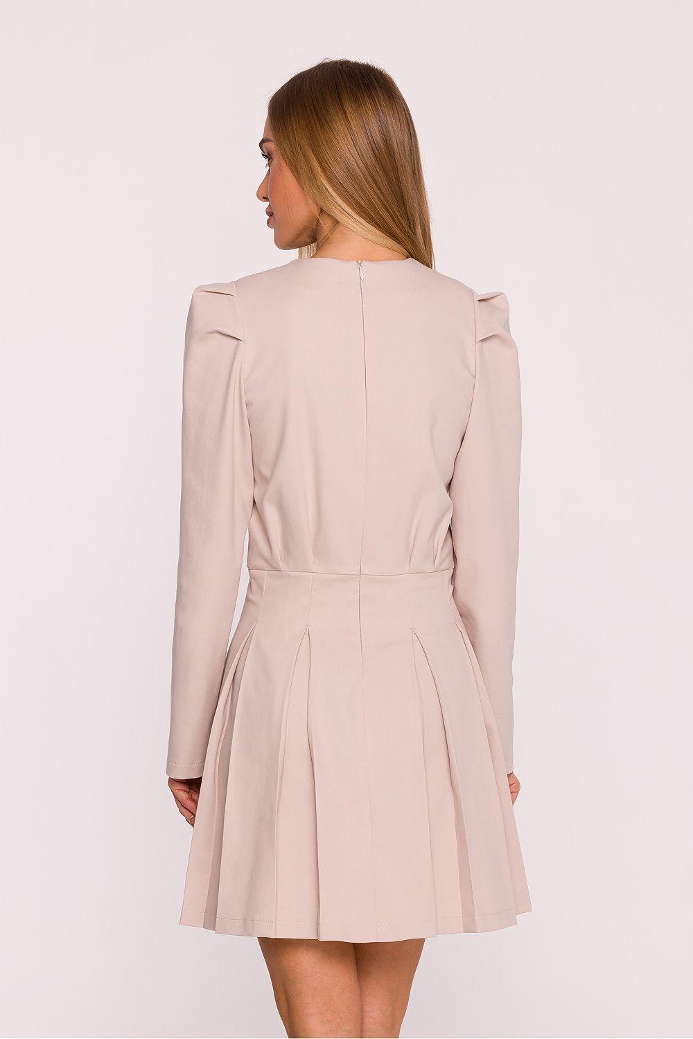 Beige daydress with long sleeves, gathered shoulders, and pleated skirt, back view.