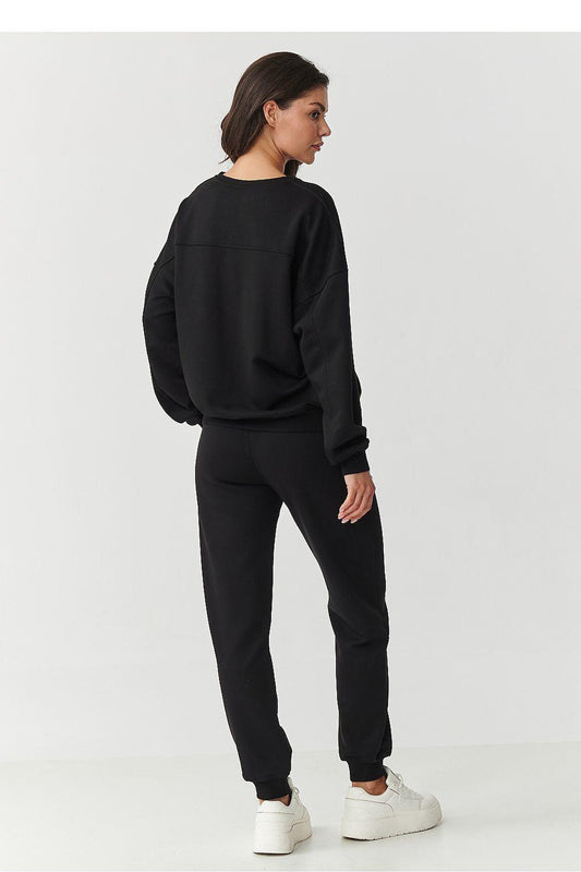Black crewneck sweatshirt and jogger pants set, side view with tapered legs.