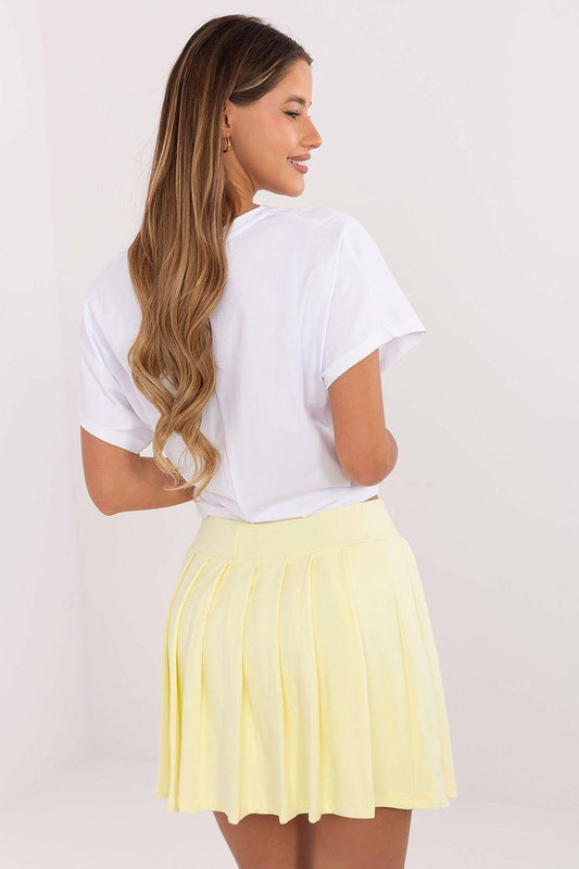 Girls' 2-piece set with white T-shirt and yellow pleated mini skirt, side view