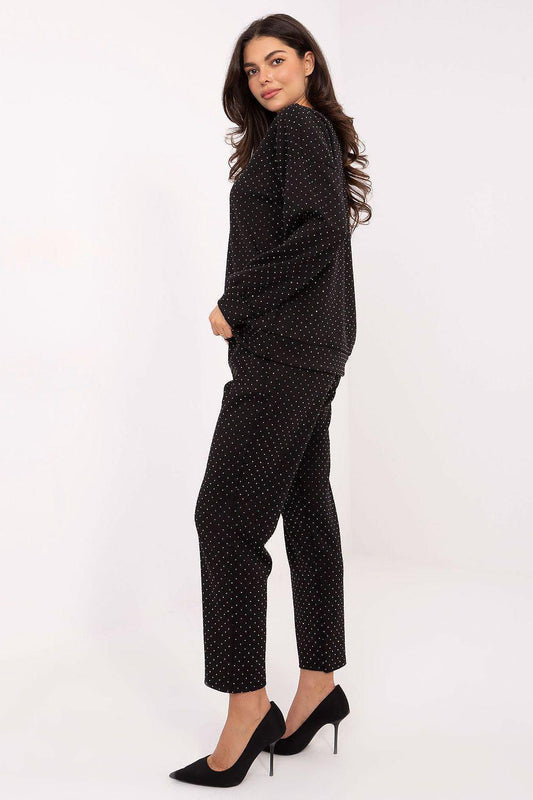 Black dotted two-piece pants set, side view: long-sleeve top with matching tapered pants