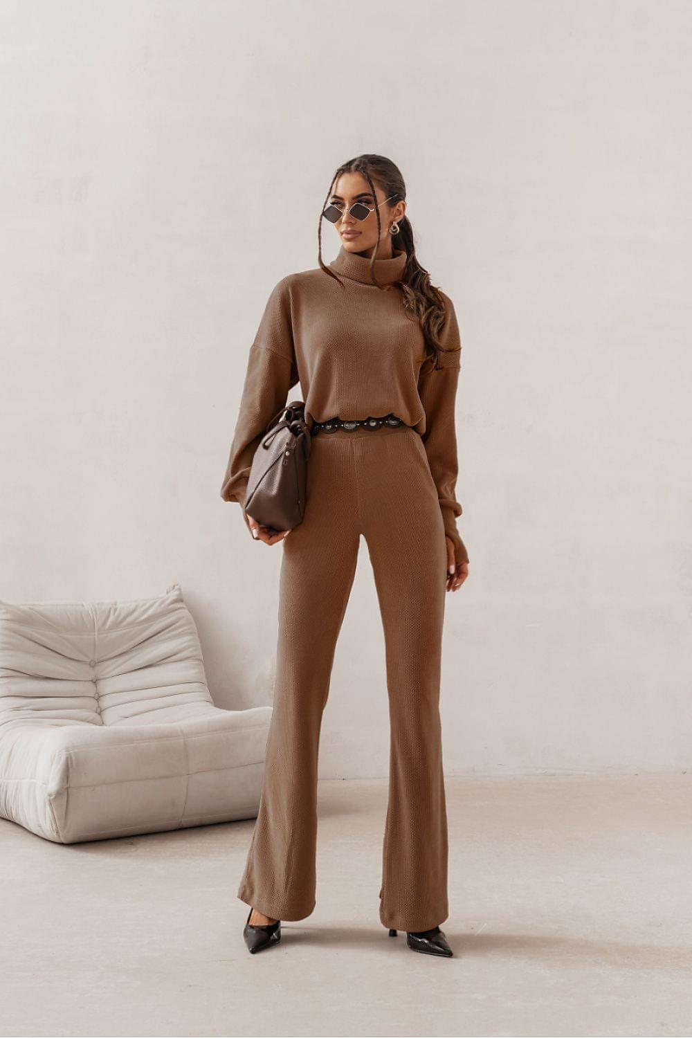 Beige turtleneck top and wide-leg pants set with belt, handbag at side