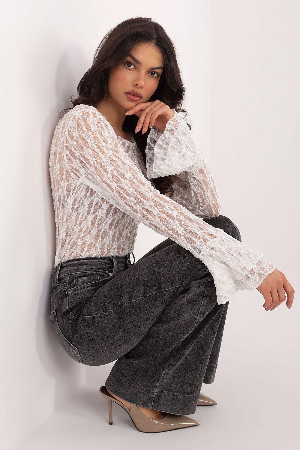 White lace blouse with sheer lace pattern, long bell sleeves and round neckline.