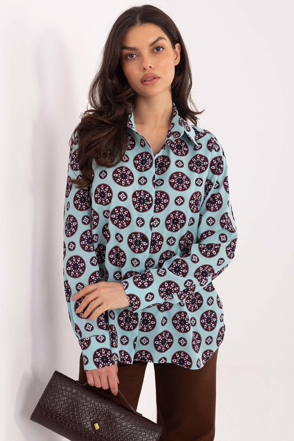 Long sleeve button-up shirt with navy and pink circular pattern on blue-green fabric