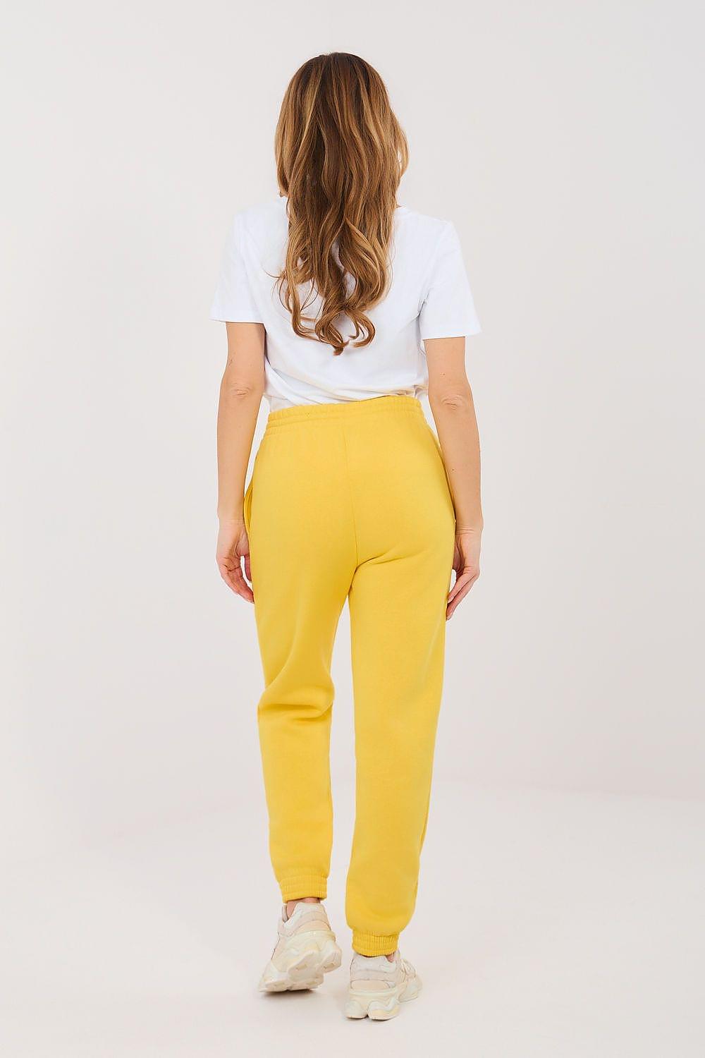 Yellow tracksuit trousers with drawstring waist and elastic ankle cuffs, worn from the back.