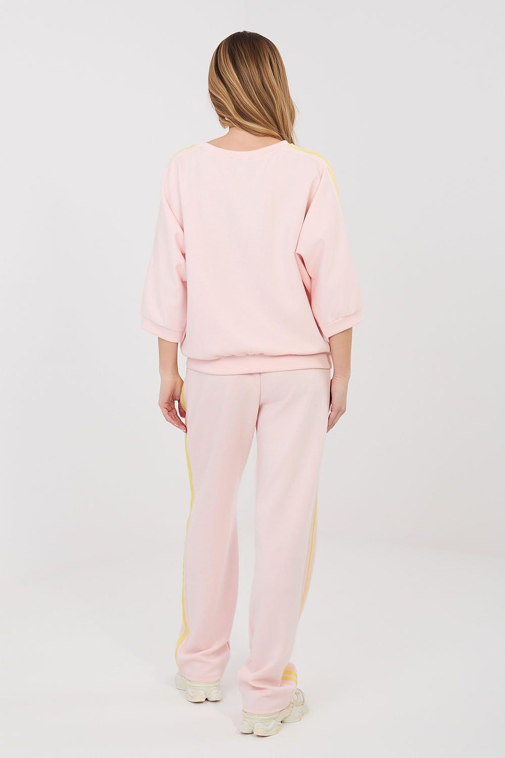 Pink sweatshirt and jogger pants set with yellow piping at seams, rear view