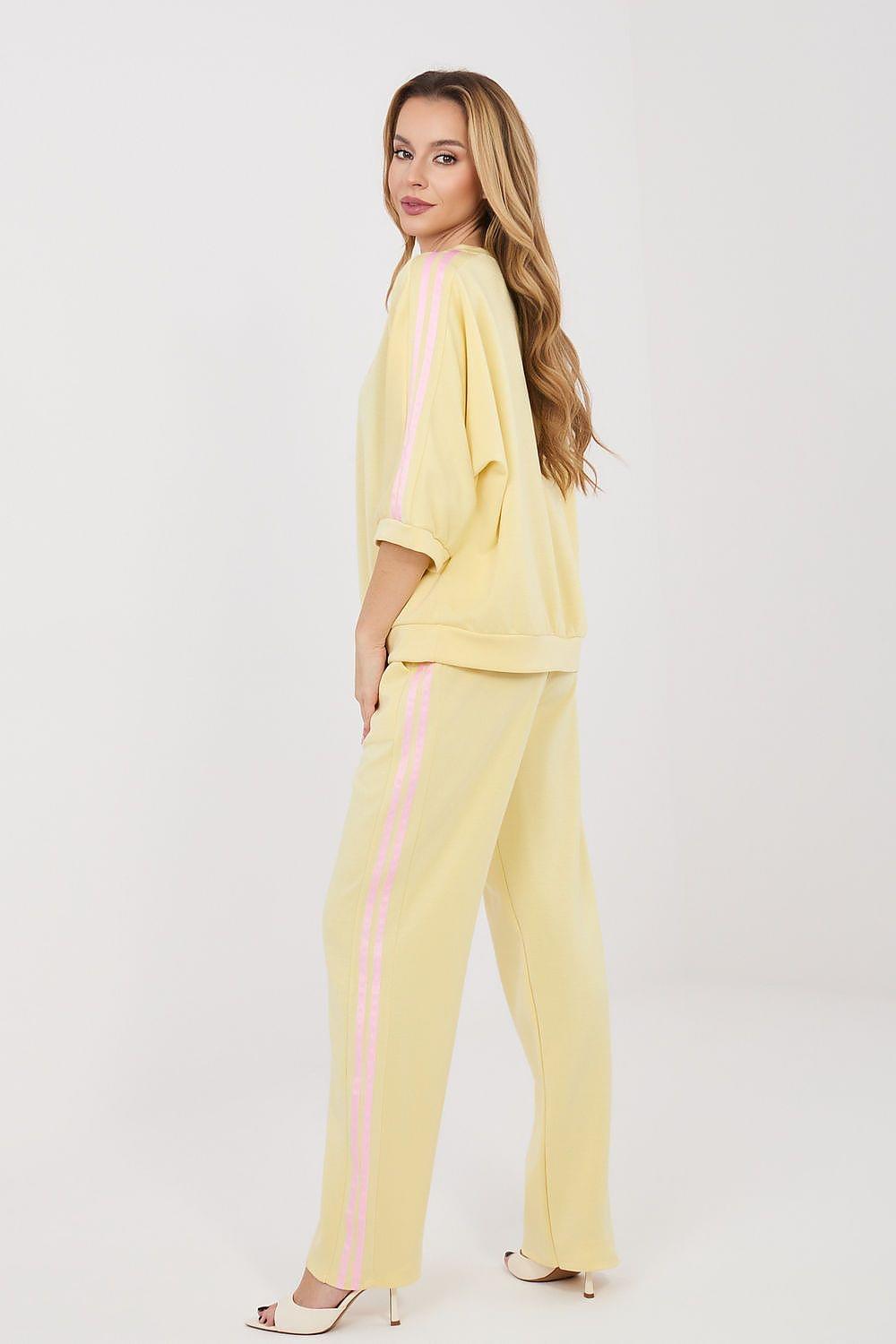 Yellow two-piece set with loose blouse and matching straight pants, side view