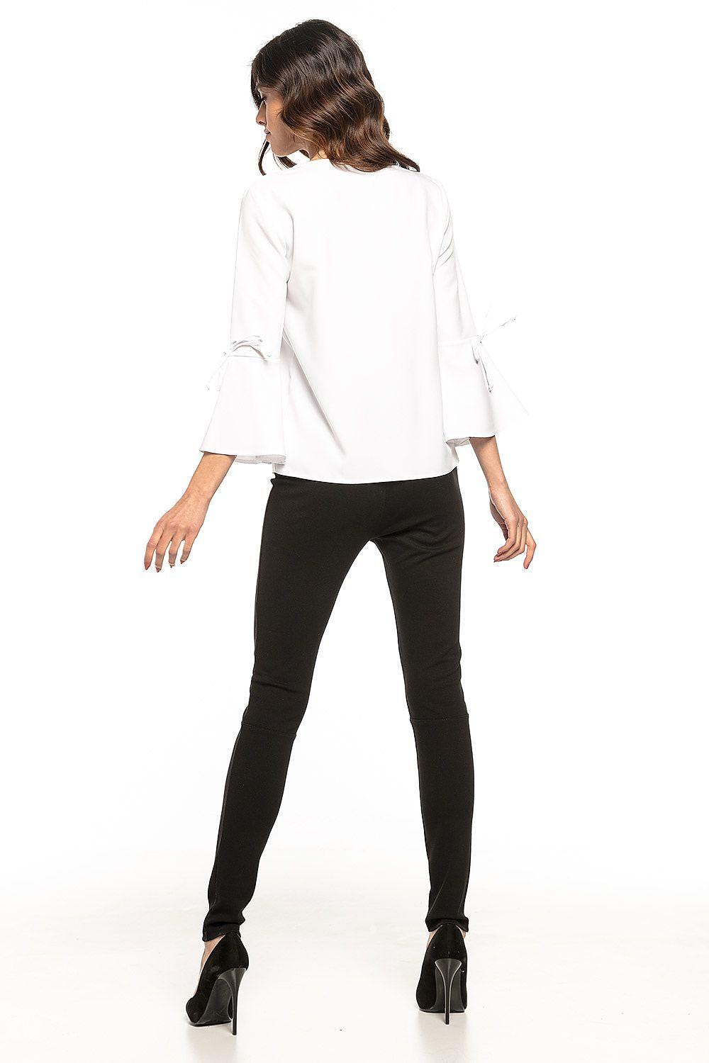 Back view of white V-neck blouse with flared sleeves and tie cuffs