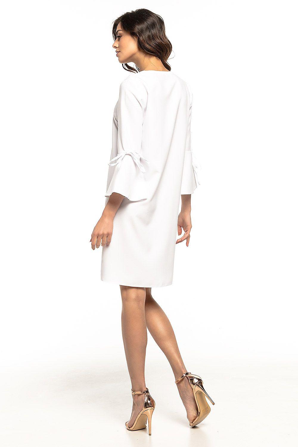 White cocktail dress with long sleeves and draped back detail, flared above-knee hem