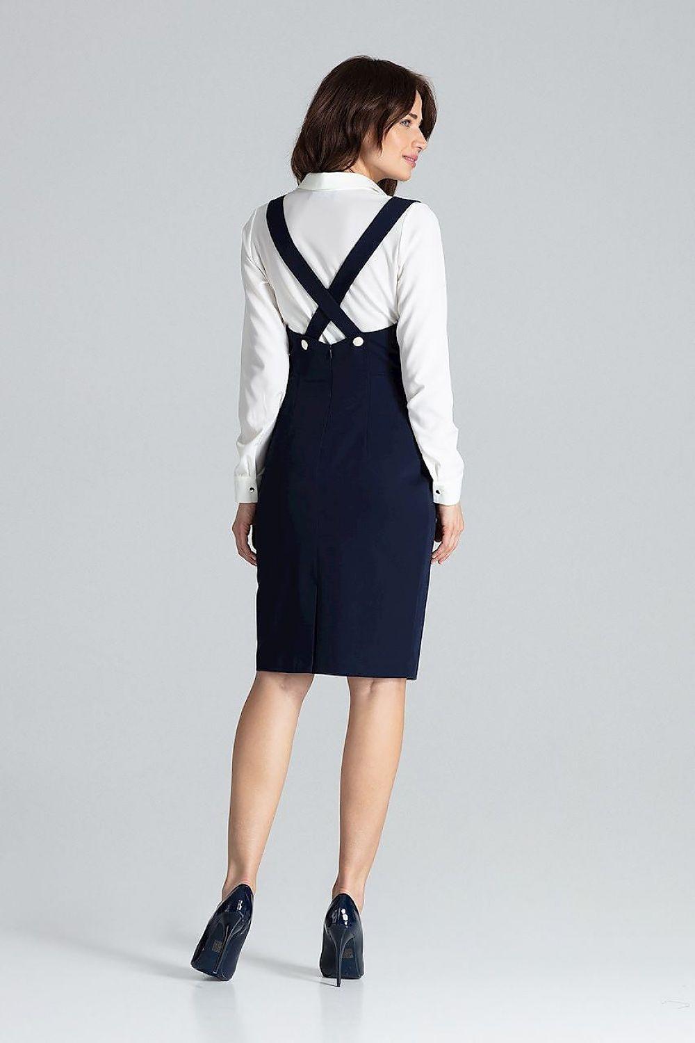 Navy daydress back with crisscross straps, white long sleeves, knee-length pinafore.