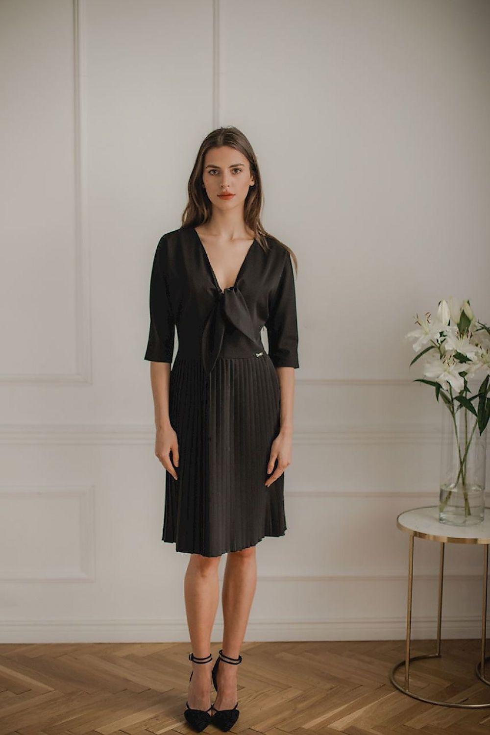 Black cocktail dress with V-neck, short sleeves, pleated skirt