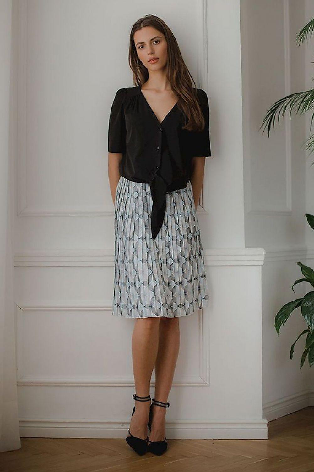 Short sleeve shirt with tied knot front in black, worn with patterned skirt