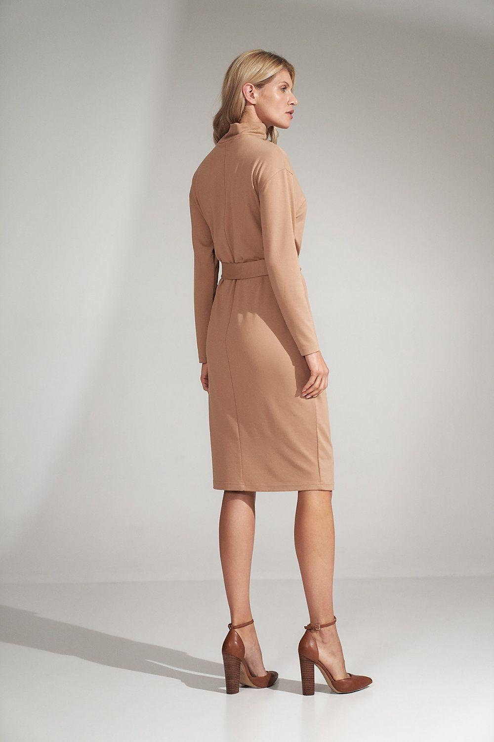Beige day dress with long sleeves and tied waist belt, midi length, side profile.