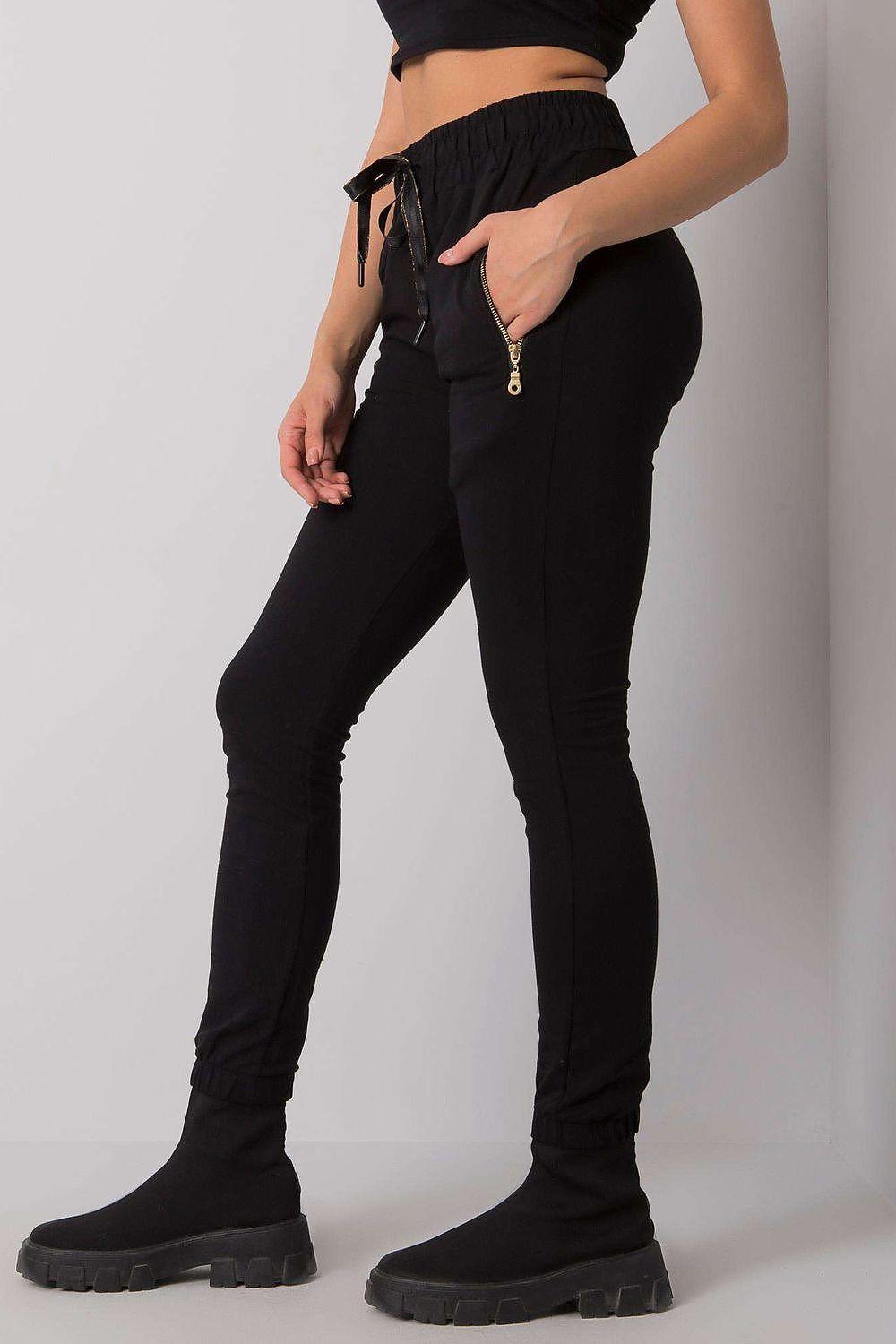 Black slim track trousers with drawstring waist and zip pocket detail, cuffed hem