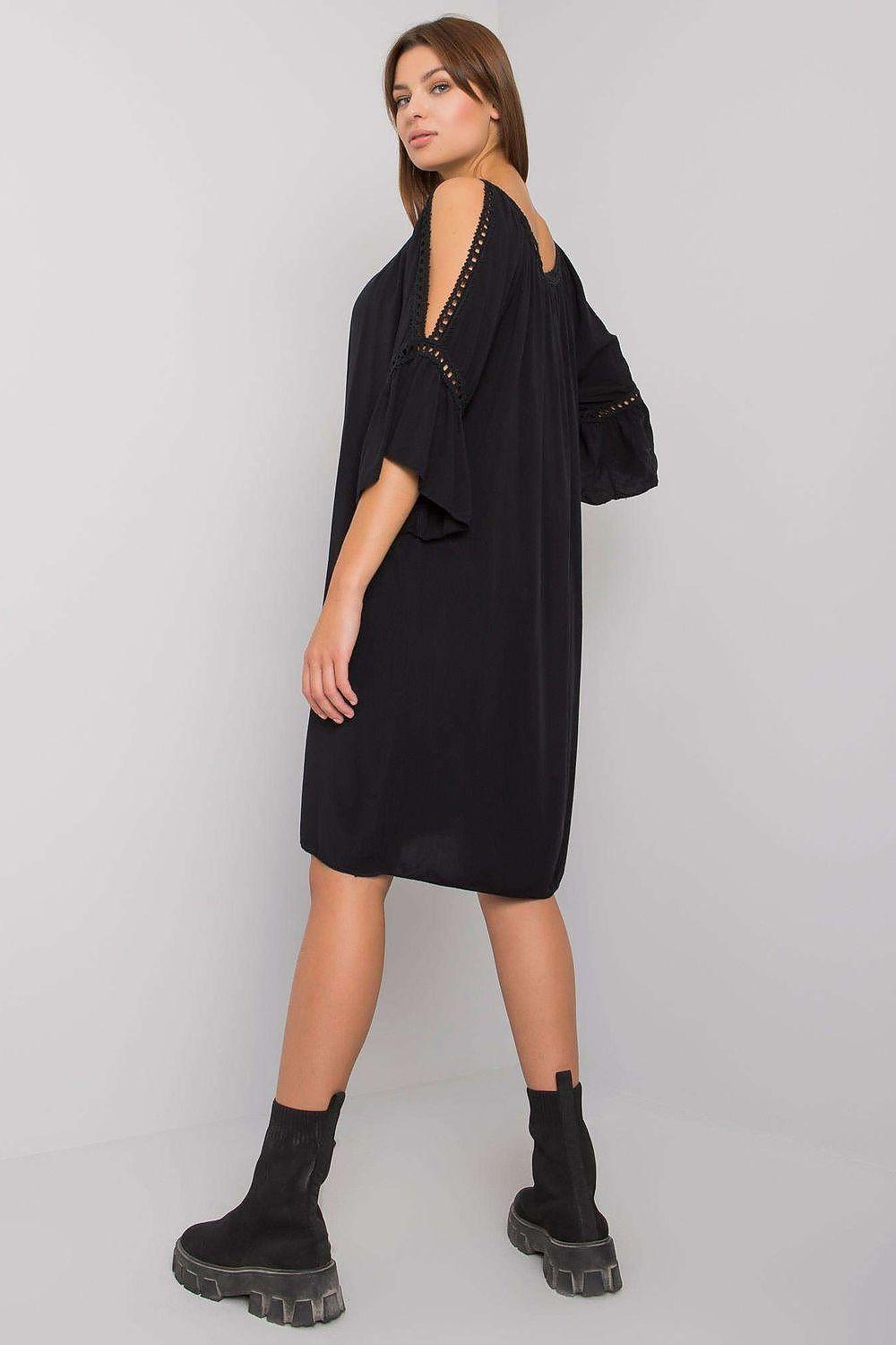 Black daydress with cold shoulder cutouts and bead trim along straps, knee length