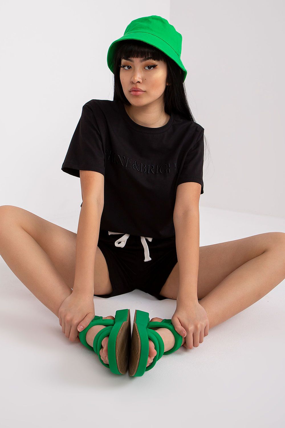 Black short-sleeve blouse and black shorts with green trim