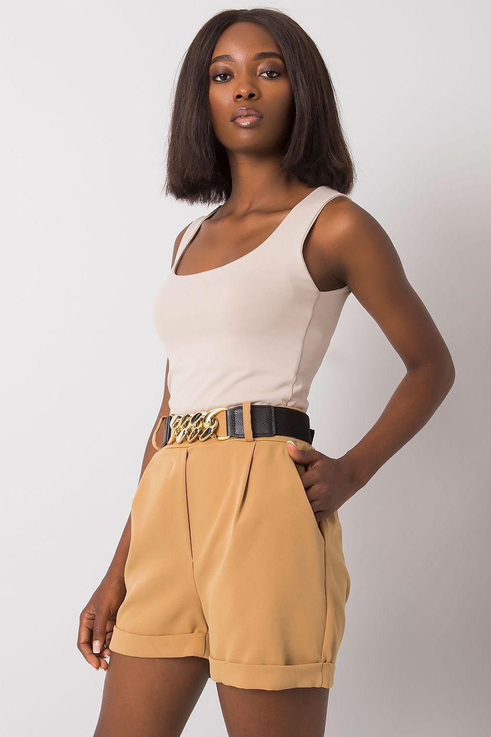 Tan tailored shorts with front pockets and gold chain belt