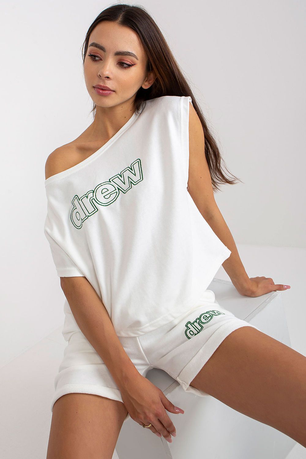 White cotton tracksuit set with one-shoulder tank top and matching logo shorts